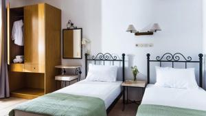 two beds sitting next to each other in a bedroom at Newcastle Studios by Estia in Malia