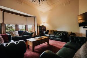 Sala de estar con sofás y mesa de centro en Green Gables King Suite en Castlemaine