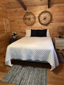 una camera con un letto e due orologi a muro di Pet Friendly, Peaceful Cabin Near Wineries, a Tryon