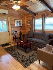 a living room with a couch and a table at Pet Friendly, Peaceful Cabin Near Wineries, in Tryon