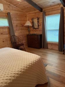una camera con letto, sedia e finestre di Pet Friendly, Peaceful Cabin Near Wineries, a Tryon