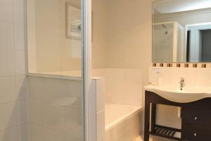 een witte badkamer met een wastafel en een douche bij KIAMA AMITY POINT in Amity Point
