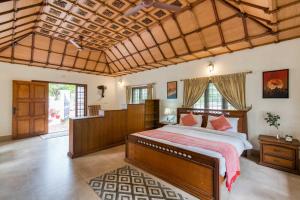 a bedroom with a large bed in a room at The Backwater Heritage- Comp Breakfast with River View & Lawn by StayVista in Alleppey