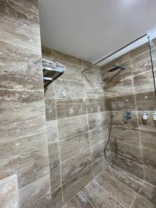 La salle de bains est pourvue d'une douche avec une porte en verre. dans l'établissement Loft, lumineux et chaleureux., à Bagnolet