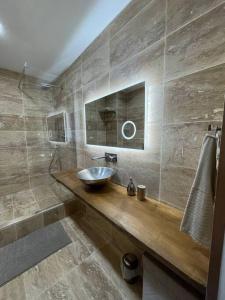 La salle de bains est pourvue d'un lavabo et d'un miroir. dans l'établissement Loft, lumineux et chaleureux., à Bagnolet