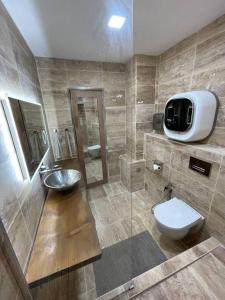 La salle de bains est pourvue d'un lavabo, de toilettes et d'une télévision. dans l'établissement Loft, lumineux et chaleureux., à Bagnolet