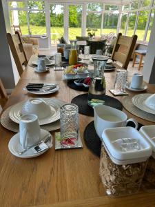 a wooden table with plates and dishes on it at Bricket House in Great Malvern