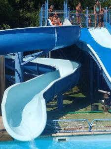 a water slide at a water park with people on it at Mobilhome bien équipé et climatisé in Mimizan