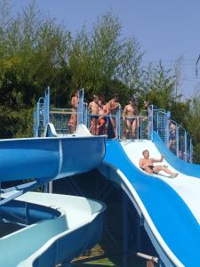 a group of people on a water slide at a water park at Mobilhome bien équipé et climatisé in Mimizan