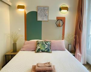 een slaapkamer met een bed met twee handdoeken erop bij Le Nid Douillet de Patricia in Parijs