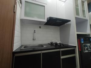 cocina pequeña con fregadero y fogones en Airin Suite en Depok