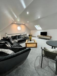 ein Wohnzimmer mit Sofa und Tisch in der Unterkunft The Annexe at Bricket House in Malvern Link