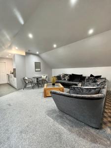 ein Wohnzimmer mit Sofa und Tisch in der Unterkunft The Annexe at Bricket House in Malvern Link