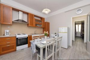 a kitchen with a table and chairs in a kitchen at AGNI'S HOUSE in Posidhonía