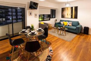 un soggiorno con divano, tavolo e sedie di Apartamento - Sky Tower 1005 a Lima
