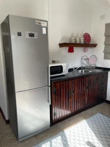 a kitchen with a refrigerator and a microwave at Comfrey cottage in Kloof