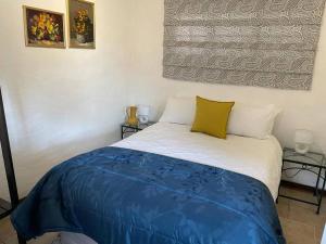 a bedroom with a bed with a blue blanket on it at Comfrey cottage in Kloof
