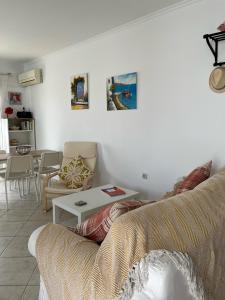 uma sala de estar com um sofá e uma mesa em Dina Apartment em Skála Kefalonias