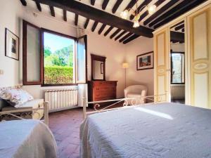 サン・ジミニャーノにあるIl Bacio Del Sole San Gimignano Apartmentsのベッドルーム(大型ベッド1台、窓付)