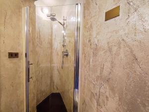サン・ジミニャーノにあるIl Bacio Del Sole San Gimignano Apartmentsのバスルーム(ガラスドア付きのシャワー付)