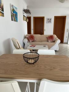 uma sala de estar com uma mesa e um sofá em Dina Apartment em Skála Kefalonias