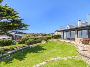 a backyard of a house with a grass yard at Trelawns in Mawgan Porth