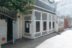 a white entrance to a building with a gate at Nearest Hostel Pasay City by RedDoorz in Manila