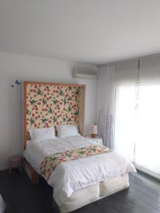 een slaapkamer met een groot bed met een bloemrijk hoofdeinde bij Beausoleil near Monaco in Beausoleil