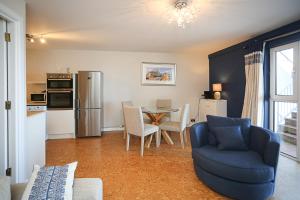 Holywood Sea Renity في هوليوود: غرفة معيشة مع كرسي ازرق وطاولة