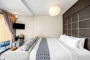 um quarto de hotel com uma cama grande e uma televisão em Sametnangshe Boutique em Phangnga