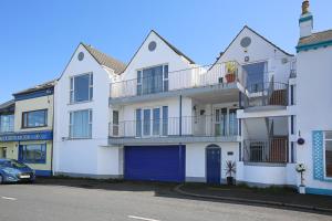 a large white building with a blue garage at Holywood Sea Renity in Holywood