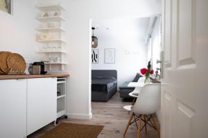 eine Küche mit weißen Schränken und ein Wohnzimmer in der Unterkunft Köhlz Appartement im 1 OG in Mertener Heide