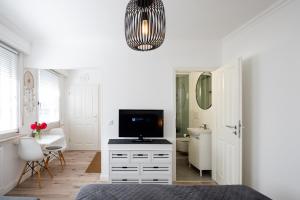 1 dormitorio con cama, TV y baño en Köhlz Appartment & Restaurant im 1. OG, 
