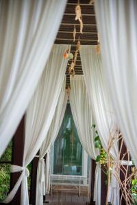 a room with white curtains and a window at Sabai Sabai@Sukhumvit Hotel in Bangkok