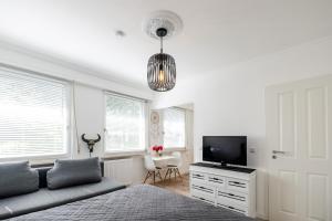 1 dormitorio con 1 cama y TV de pantalla plana en Köhlz Appartment & Restaurant im 1. OG, 