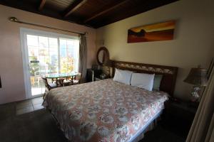 a bedroom with a bed and a window and a table at Edgewater Beach Inn & Suites in Santa Cruz