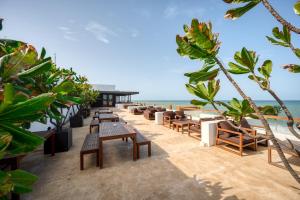 a row of tables and benches on the beach at Riff Hikkaduwa in Hikkaduwa