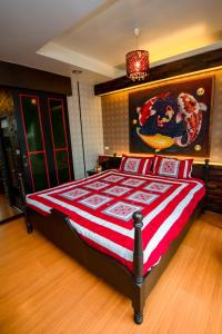 Schlafzimmer mit einem Bett mit einer roten und weißen Decke in der Unterkunft Sabai Sabai@Sukhumvit Hotel in Bangkok