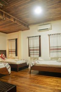a room with two beds and a fan in it at laolulodge in Luang Prabang