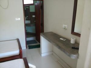 Habitación con baño con encimera y lavabo. en Inn On The Bay Home en Kalkudah