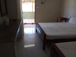 una camera con 2 letti e una porta che conduce a un patio di Inn On The Bay Home a Kalkudah