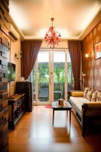 ein Wohnzimmer mit einem Sofa und einem Kronleuchter in der Unterkunft Sabai Sabai@Sukhumvit Hotel in Bangkok