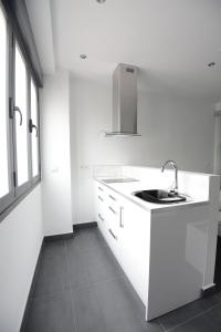 cocina blanca con fregadero y ventana en Apartamentos Torrecilla, en Jarandilla de la Vera