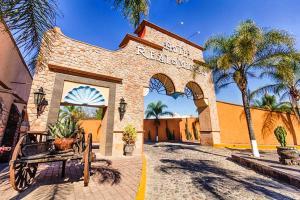 a brick building with palm trees in front of it at Hotel Real de Minas Tradicional in Querétaro