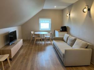 a living room with a couch and a table at Mazā Kaija in Bērzciems