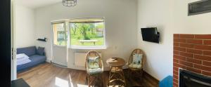 a living room with a couch and chairs and a window at Rybakówka Nad Jeziorem Wicko in Jezierzany
