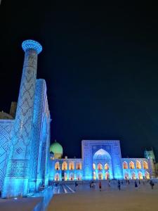 a building lit up in blue at night at Royal lux Guest House in Samarkand
