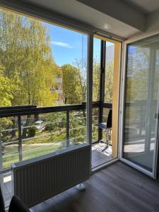 a room with a large glass door with a balcony at Topoliai Apartament Self check -in in Panevėžys