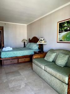 Luana Waikiki Park Views في هونولولو: غرفة معيشة بها سريرين وأريكة
