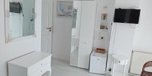 a white room with white furniture and a tv at хотел Кристиан in Sozopol +61 photos